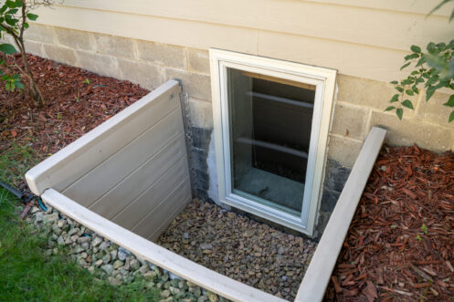 Exterior view of a basement window in spring