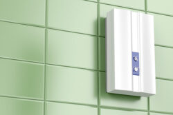 tankless water heater mounted on a green tile wall installed by Dog House